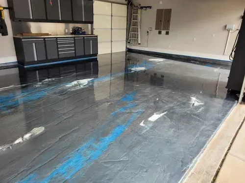 Explore a wide-angle view of a garage project, featuring a seamless silver metallic base coat elevated with striking ocean blue pearlescent waves.  Custom Silver & Ocean Blue Metallic Floor by Global Garage Flooring & Design Houston. Custom Silver & Ocean Blue Metallic Floor by Global Garage Flooring & Design Houston