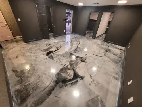 Admire the seamless depth of a commercial lobby space, highlighting a premium high-gloss silver metallic floor with dynamic charcoal swirls.