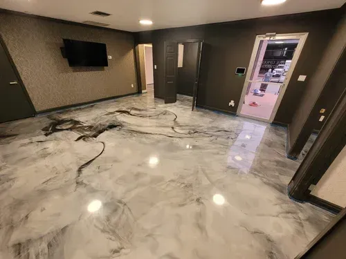 Admire the seamless depth of a commercial lobby space, highlighting a premium high-gloss silver metallic floor with dynamic charcoal swirls.