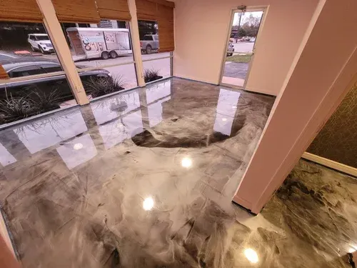 Admire the seamless depth of a commercial lobby space, highlighting a premium high-gloss silver metallic floor with dynamic charcoal swirls.