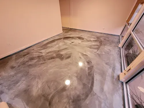 Admire the seamless depth of a commercial lobby space, highlighting a premium high-gloss silver metallic floor with dynamic charcoal swirls.