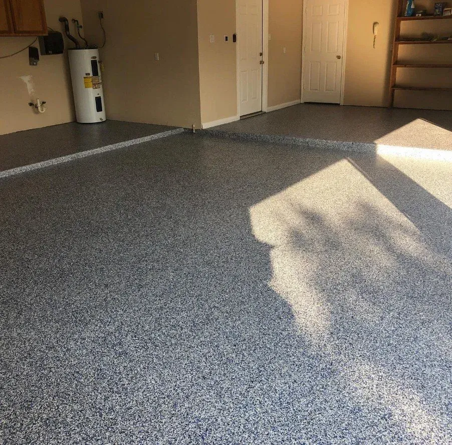 Empty carpeted room with beige walls, white door, and sunlight casting shadows across the floor