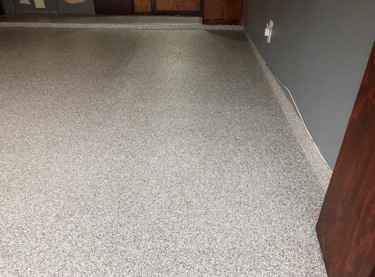 Carpeted hallway corner with gray walls and wooden trim