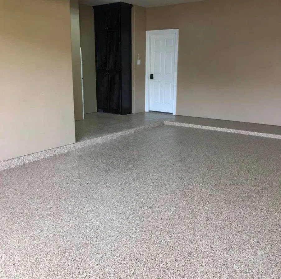 Empty carpeted room with beige walls, a white door, and a dark closet nook.