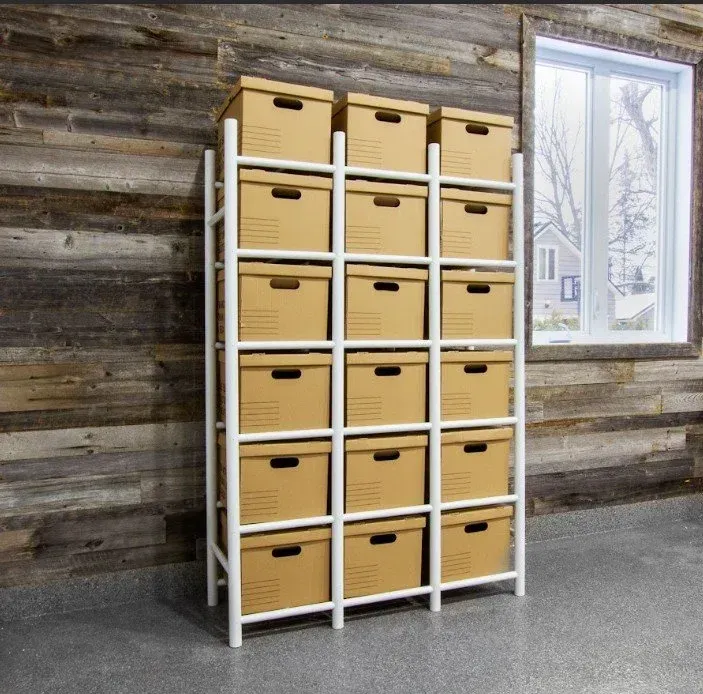 White shelving unit filled with tan storage boxes in a rustic room beside a window