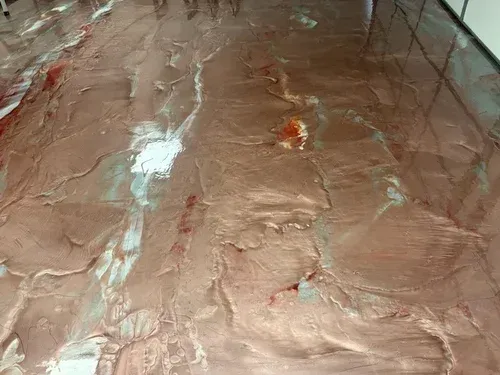 Get a close-up look at a fluid three-dimensional floor finish, showcasing rich copper metallic pigments beautifully blended with deep crimson and silver ribbon accents.
