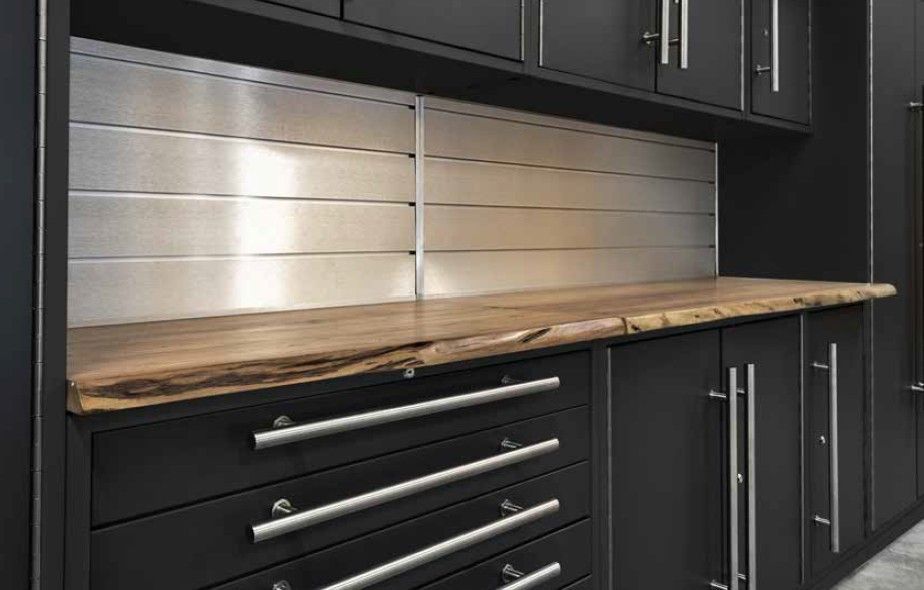Premium ProSlat LUX garage cabinets paired with a natural live‑edge wood countertop, creating a warm, modern workspace designed by Global Garage Flooring & Design.