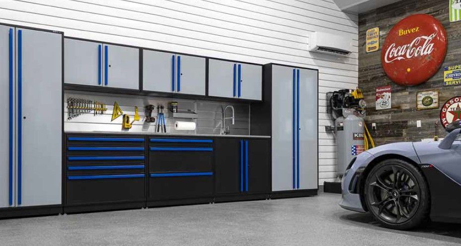 A modern garage featuring gray and blue ProSlat FusionPlus cabinets, tool organization, and automotive‑themed décor—perfect for both car enthusiasts and hobbyists.