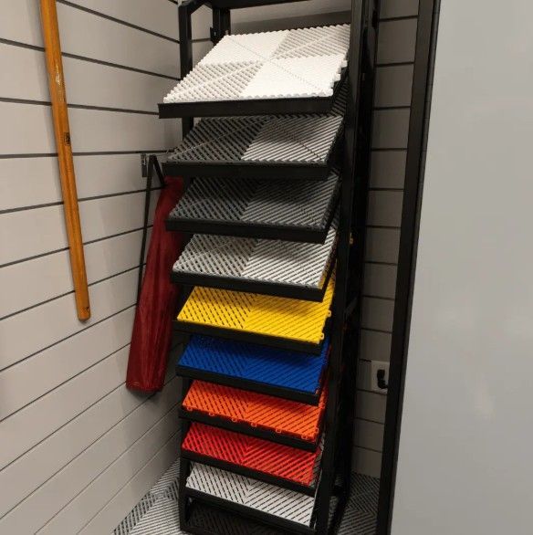 A neatly organized display of SwissTrax interlocking garage floor tiles in multiple color combinations, showcasing versatile flooring choices.