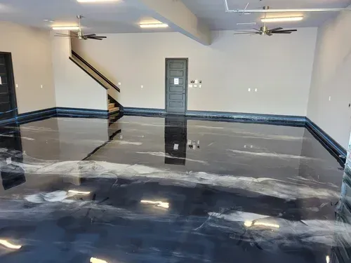 Explore a massive interior garage space featuring a high-gloss, mirror-like onyx metallic epoxy floor accented by shimmering silver veins in Metallic floor
