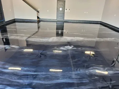 Explore a massive interior garage space featuring a high-gloss, mirror-like onyx metallic epoxy floor accented by shimmering silver veins in Metallic floor