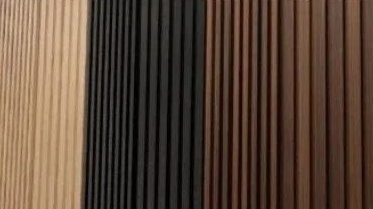 Vertical wood slats in beige, black, and brown tones forming a striped wall pattern