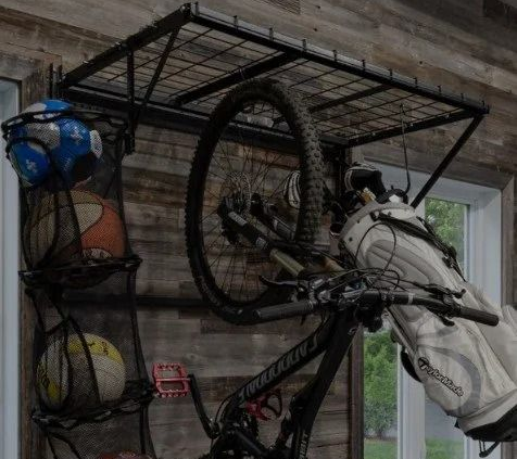 Bicycles and helmets stored on wall-mounted racks in a garage beside a window