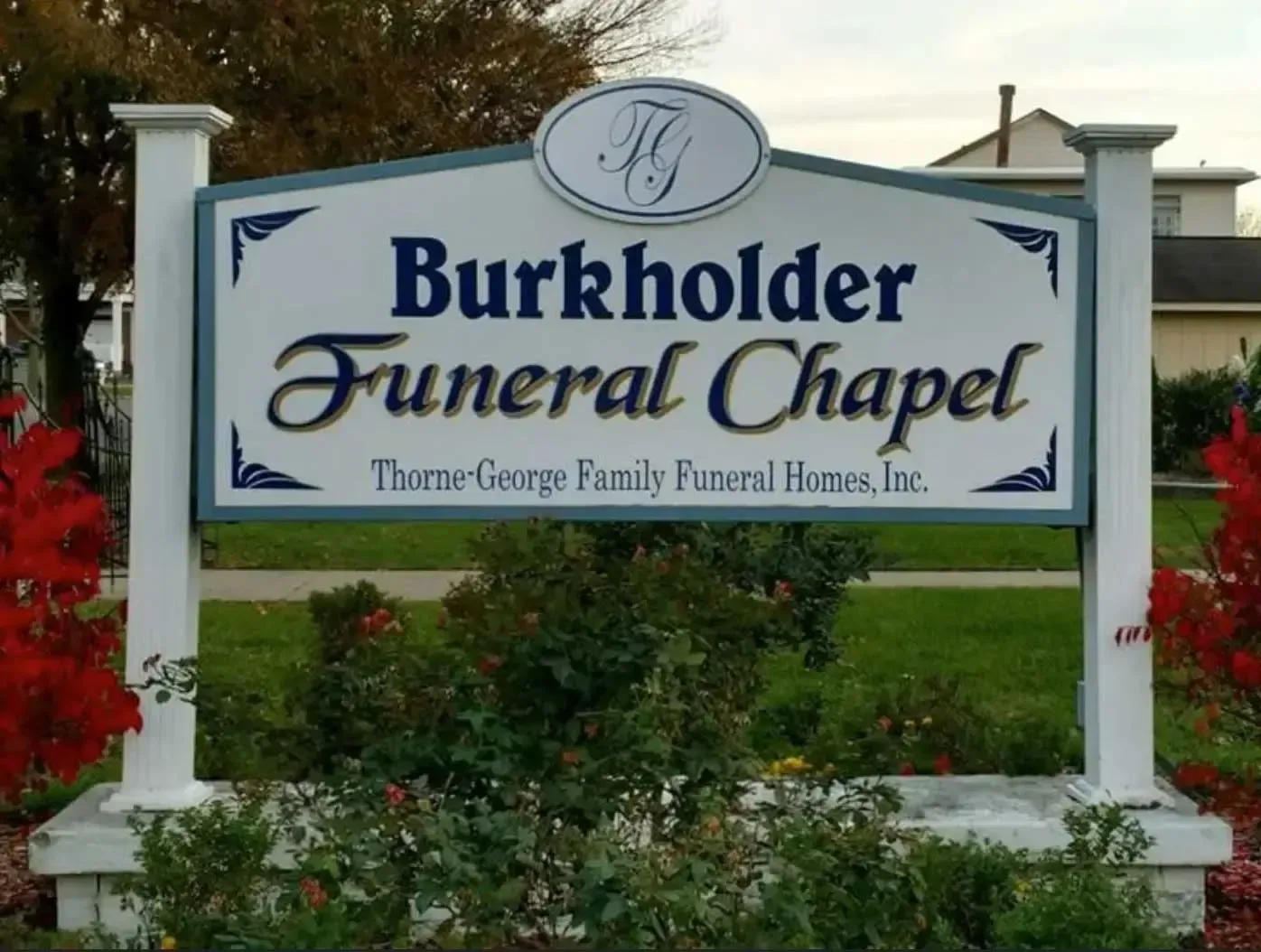 Burkholder Funeral Chapel sign in front of a landscaped building entrance