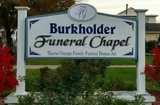 Burkholder Funeral Chapel sign in a landscaped outdoor setting