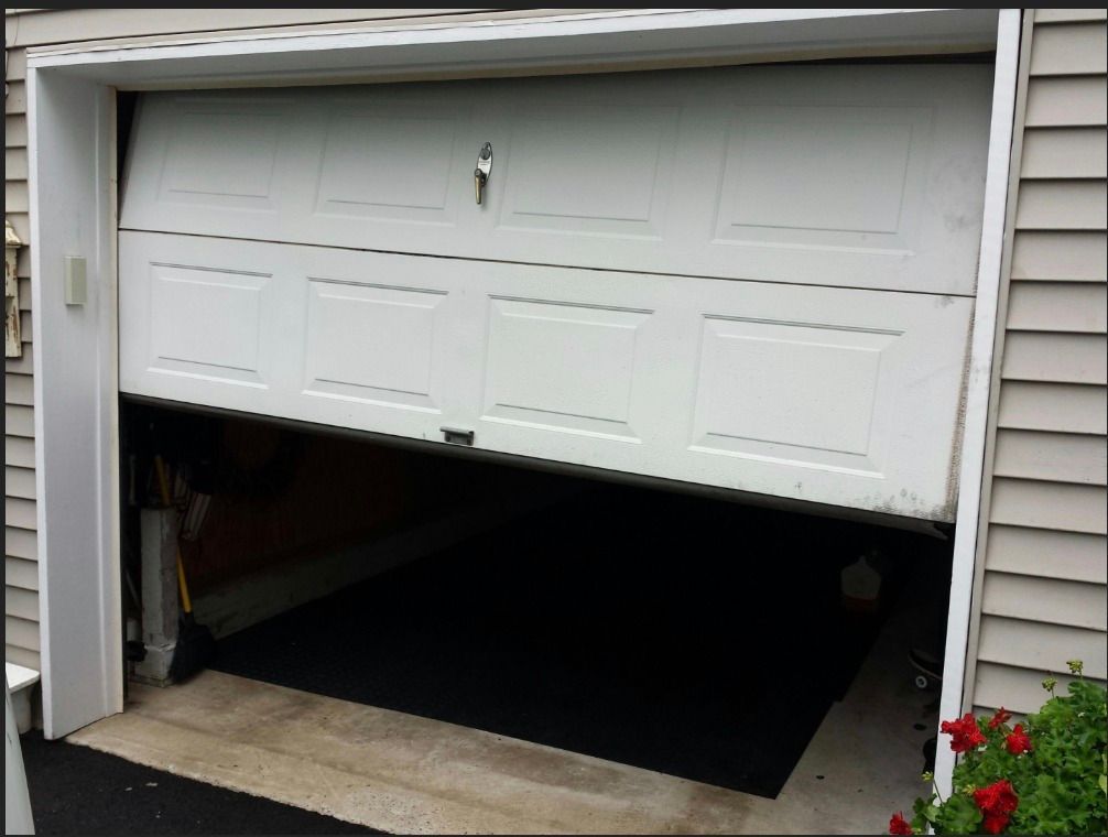 A white garage door that is open and broken