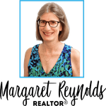 The logo for margaret reynolds realtor shows a woman wearing glasses and a blue top.