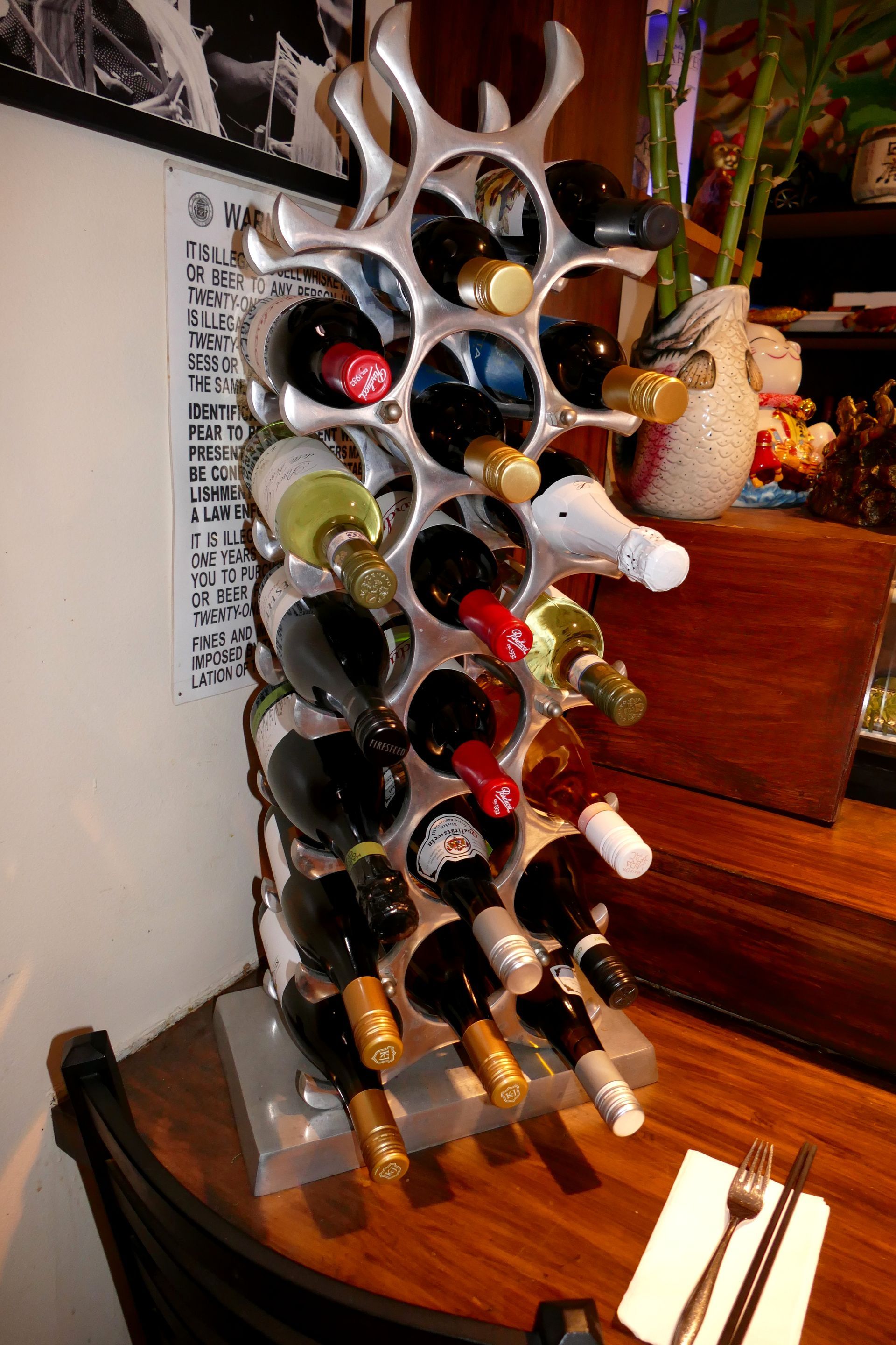 Wine bottle rack mounted on a staircase wall, holding multiple bottles tilted upside down.