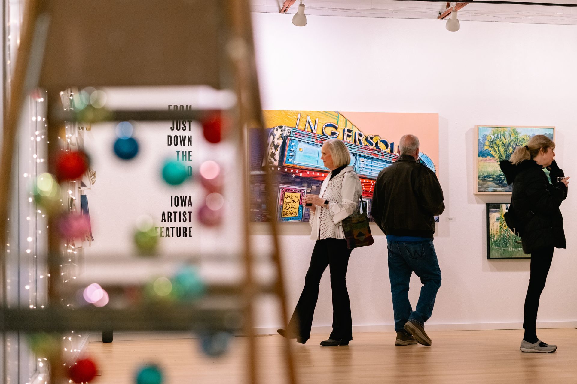 Woman gazing at art with Christmas tree in forefront