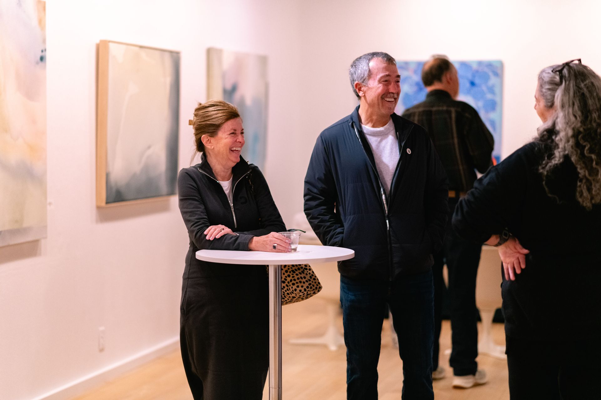 two guests standing at a cocktail table