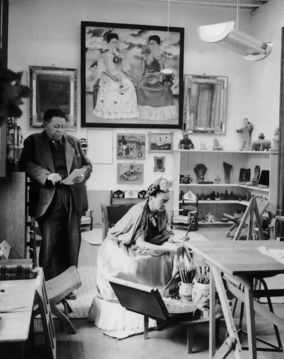 Diego Rivera and Frida Kahlo. Kahlo’s self-portrait, The Two Fridas (1939), hangs in the background. Photograph: Hulton Archive/Getty Images