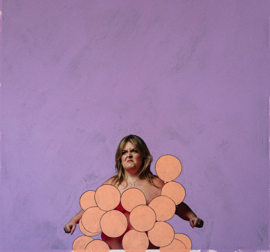purple background featuring a woman wearing pink balloons shaped like a grape