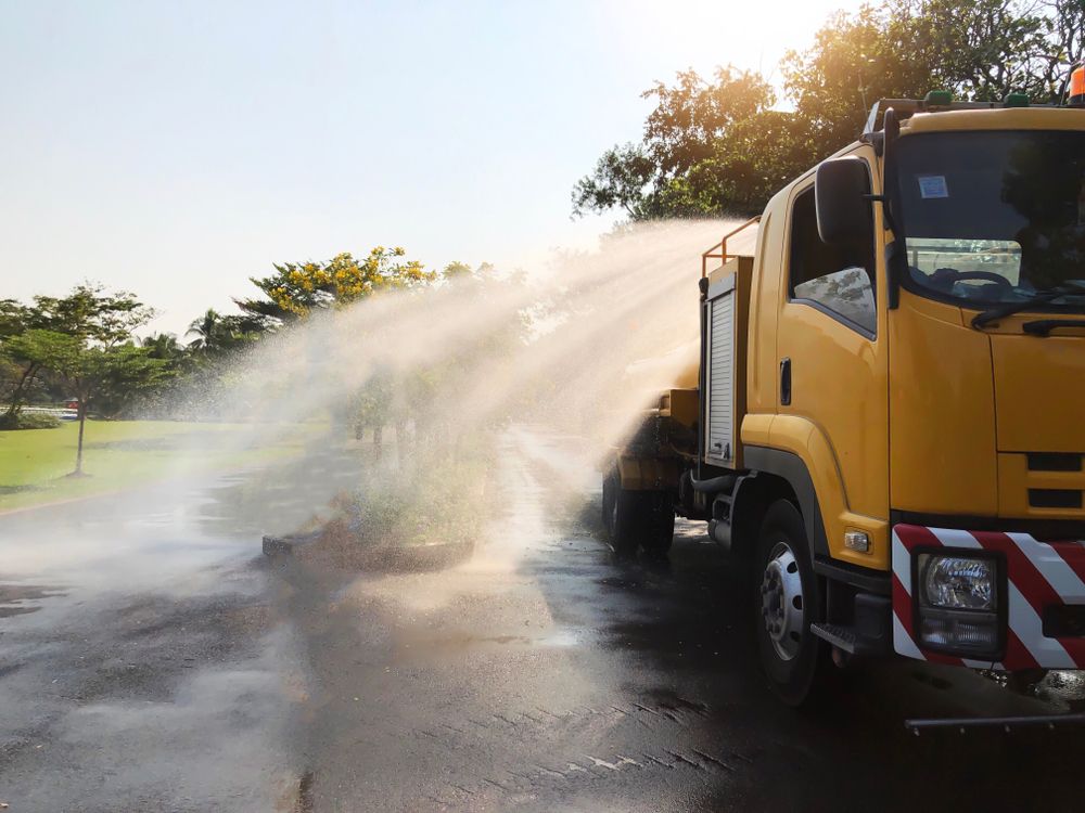 A Yellow Truck is Spraying Water on a Road — Sue's Clear Water in Mackay, QLD