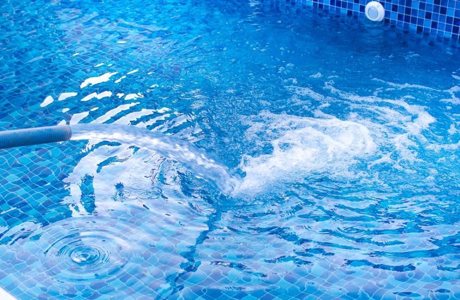 A Hose is Spraying Water Into a Swimming Pool — Sue's Clear Water in Calen, QLD