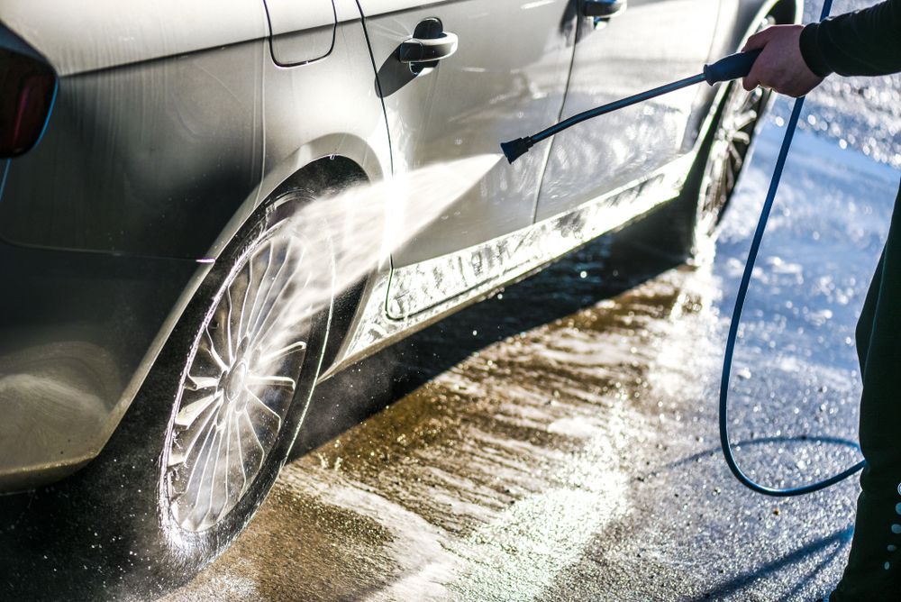 A Person is Washing a Car With a High Pressure Washer — Sue's Clear Water in Walkerston, QLD
