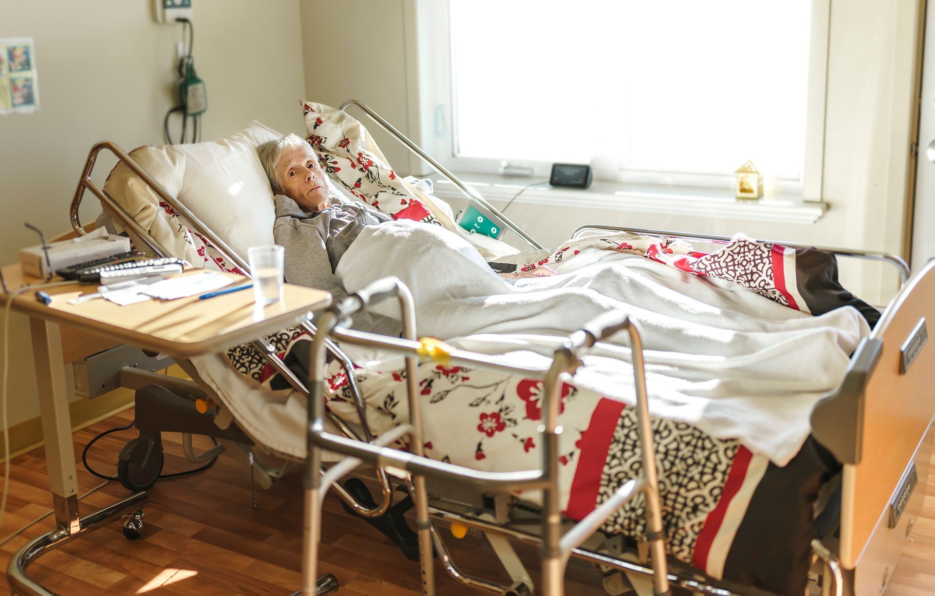 Hospital beds in a bright ward, with blue and white frames and wheels