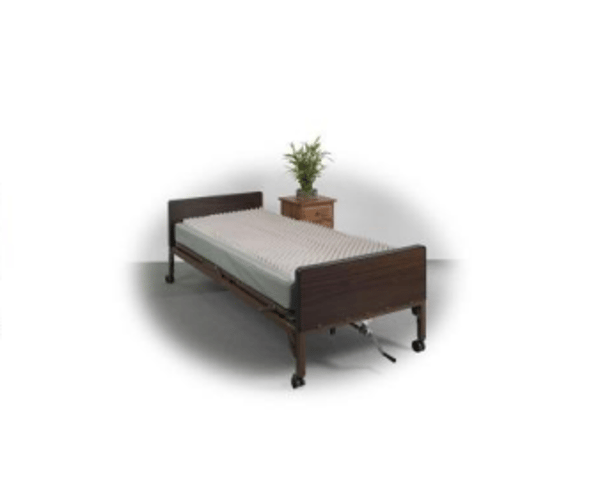 Single bed with dark wood frame and gray bedding, next to a small potted plant.