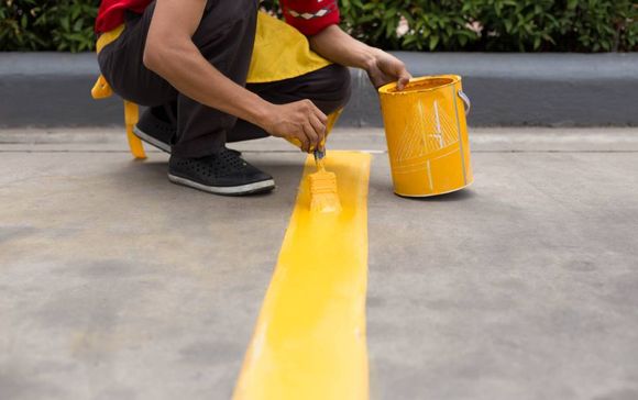 man painting a yellow line