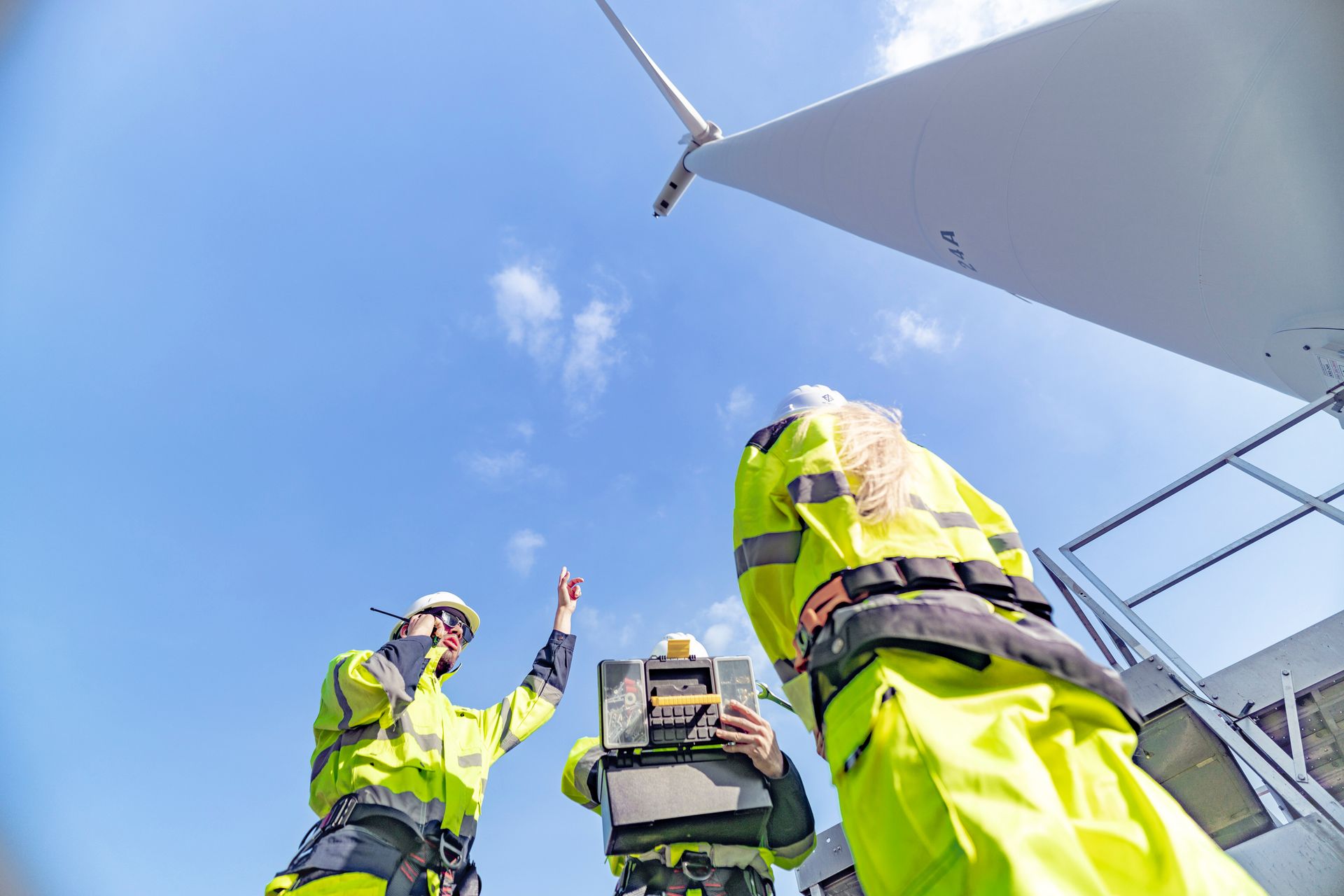 Worker installing solar panels in a field, wearing a hard hat and safety vest. Worker installing solar panels in a field, wearing a hard hat and safety vest.