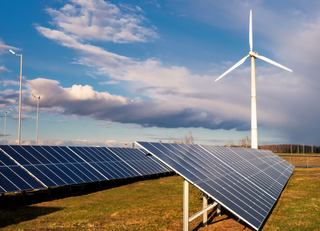 Solar panels and wind turbine generating renewable energy outdoors under a cloudy sky. Solar panels and wind turbine generating renewable energy outdoors under a cloudy sky.