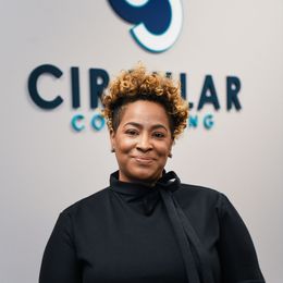a woman is smiling in front of a sign that says circular