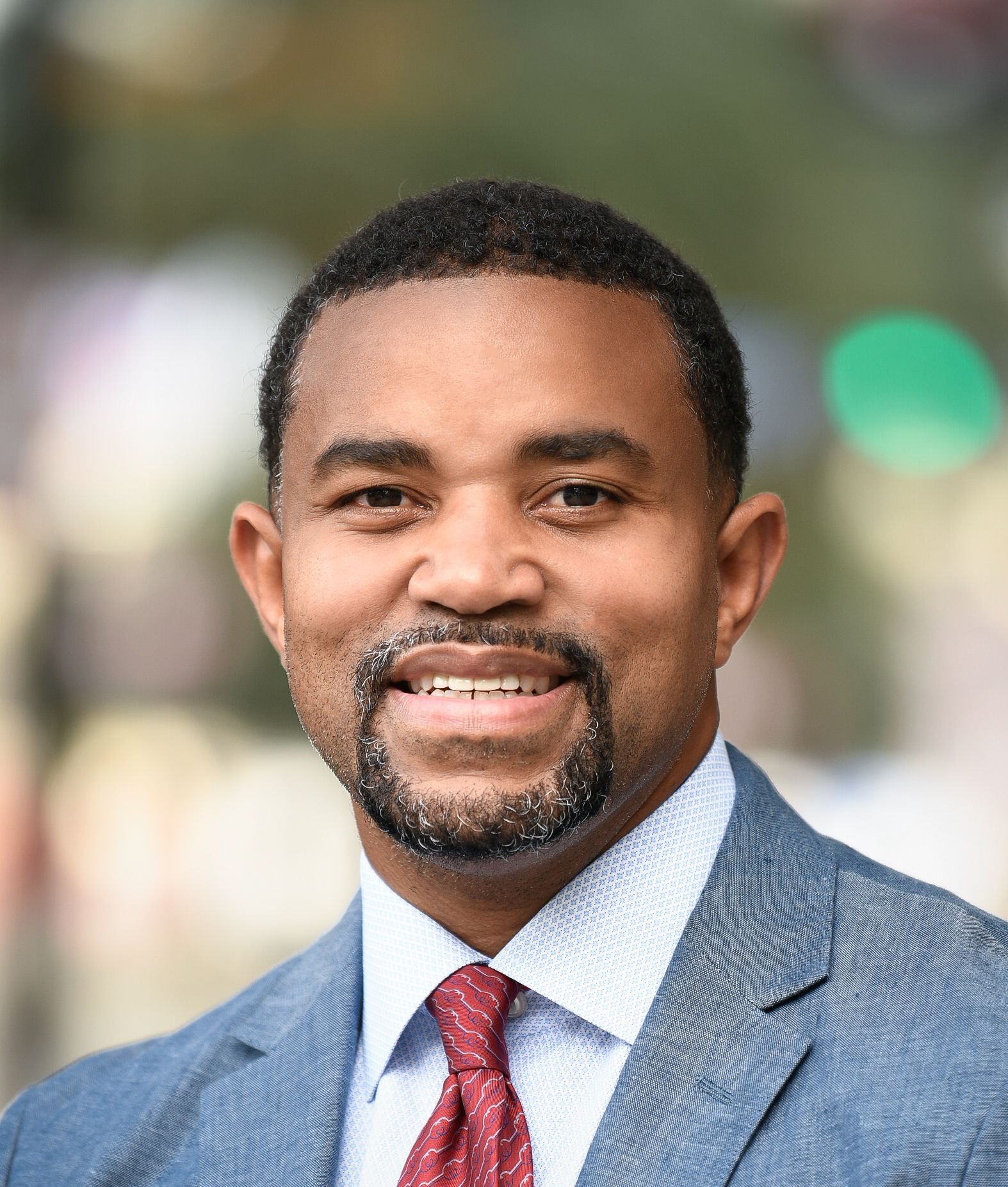 a man in a suit and tie is smiling for the camera .