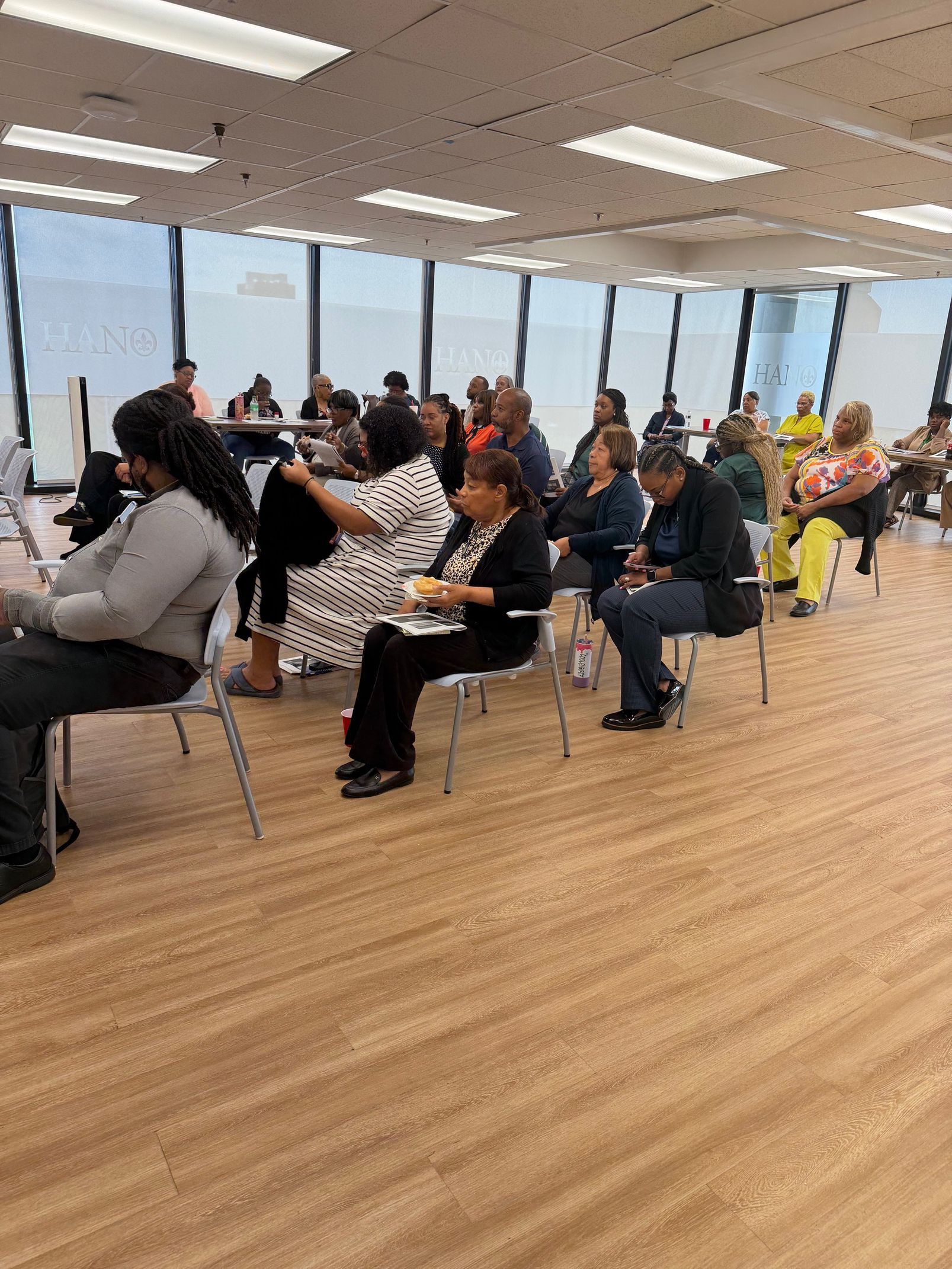A man is giving a presentation to a group of people sitting at tables.