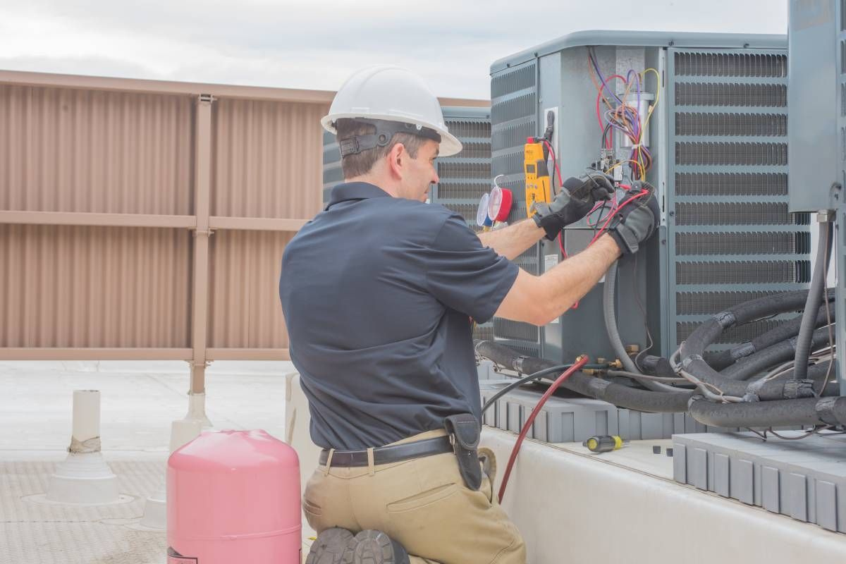 An HVAC technician inspecting a condenser near Lexington, Kentucky (KY)