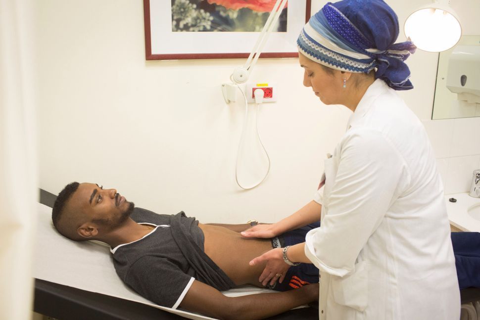 Yosef Yabarkan, left is being examined by his doctor, for signs of Crohn's disease.