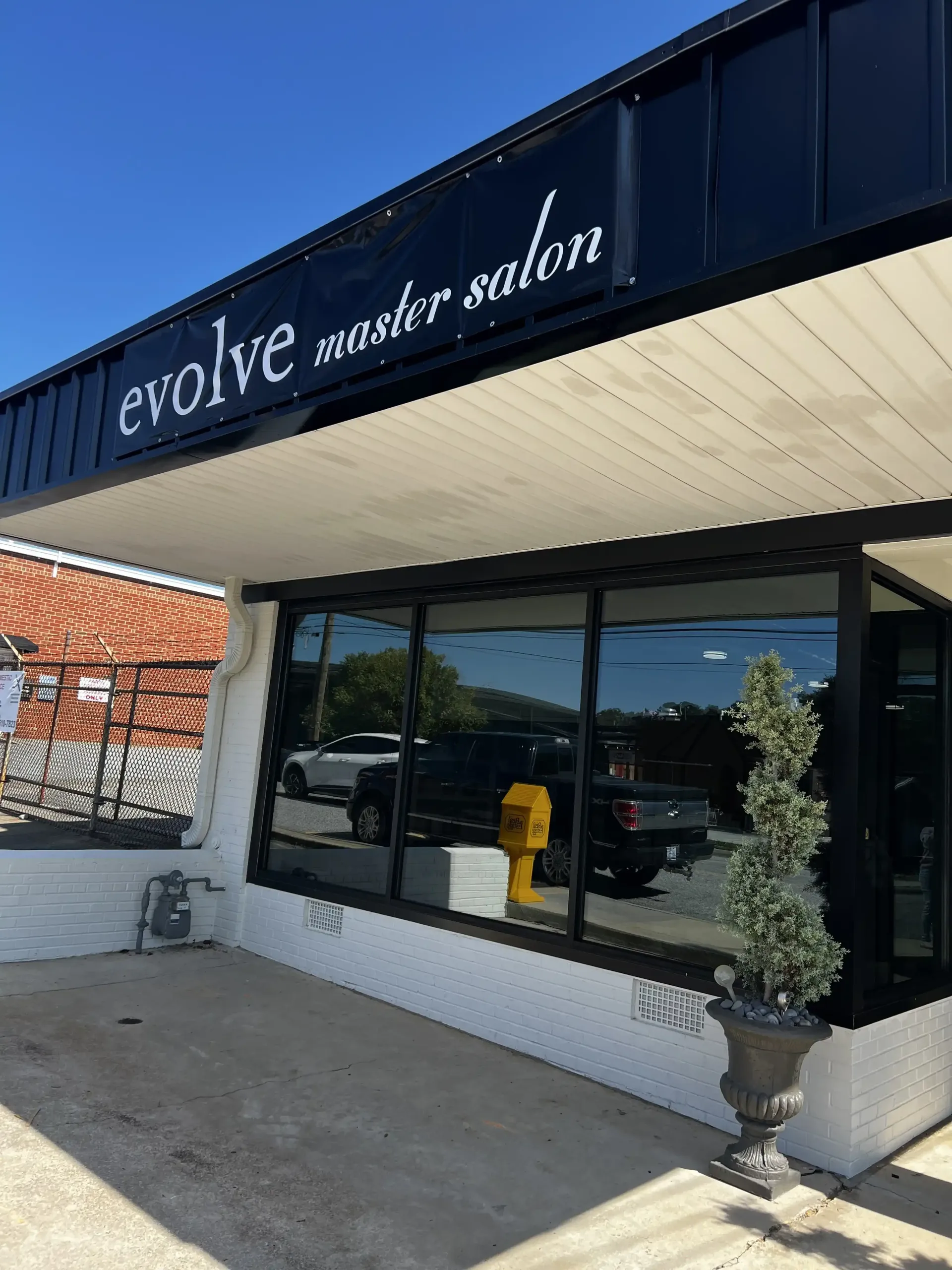 A black and white building with a sign that says evolve master salon.