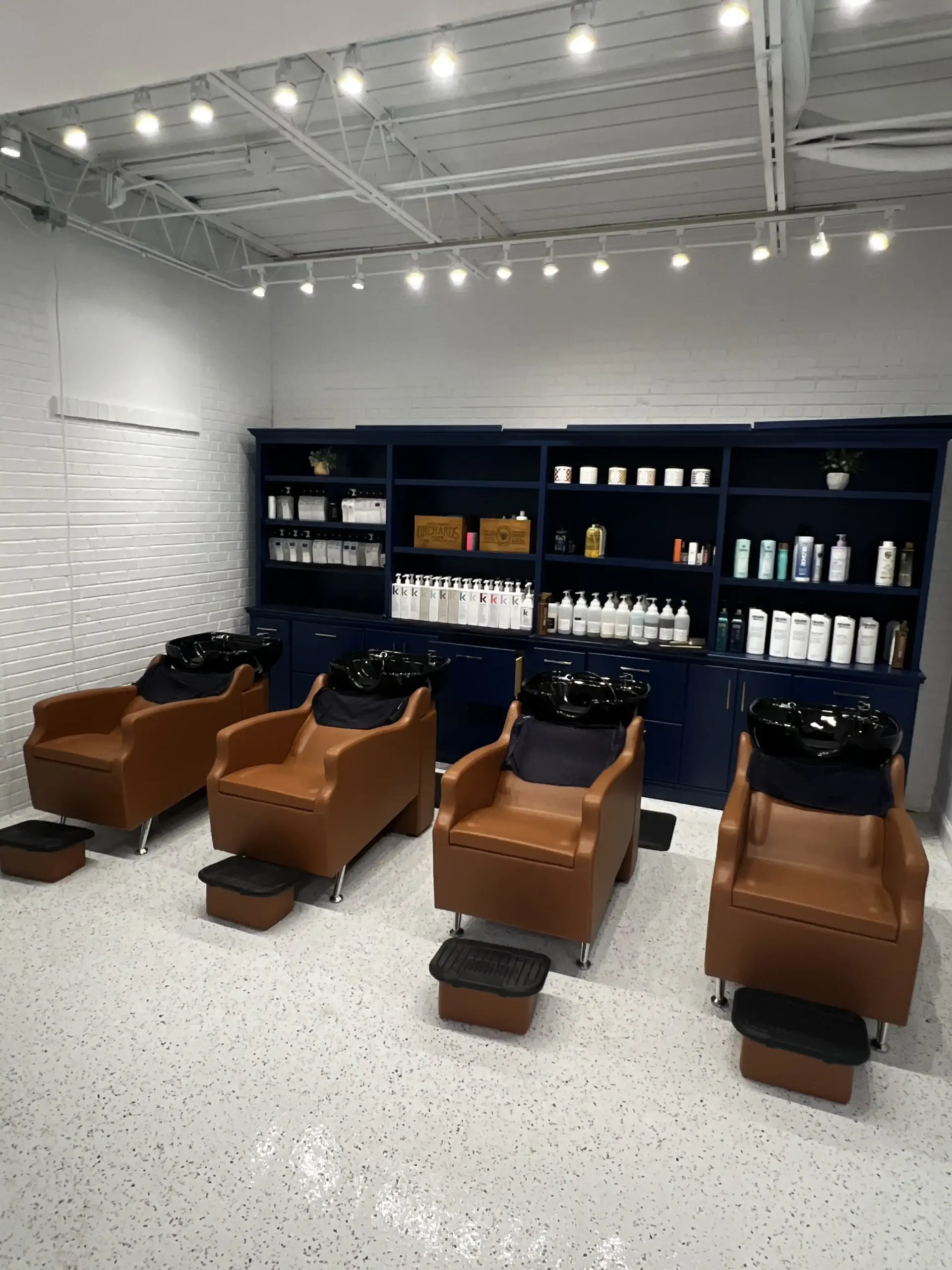 A row of chairs and sinks in a hair salon.