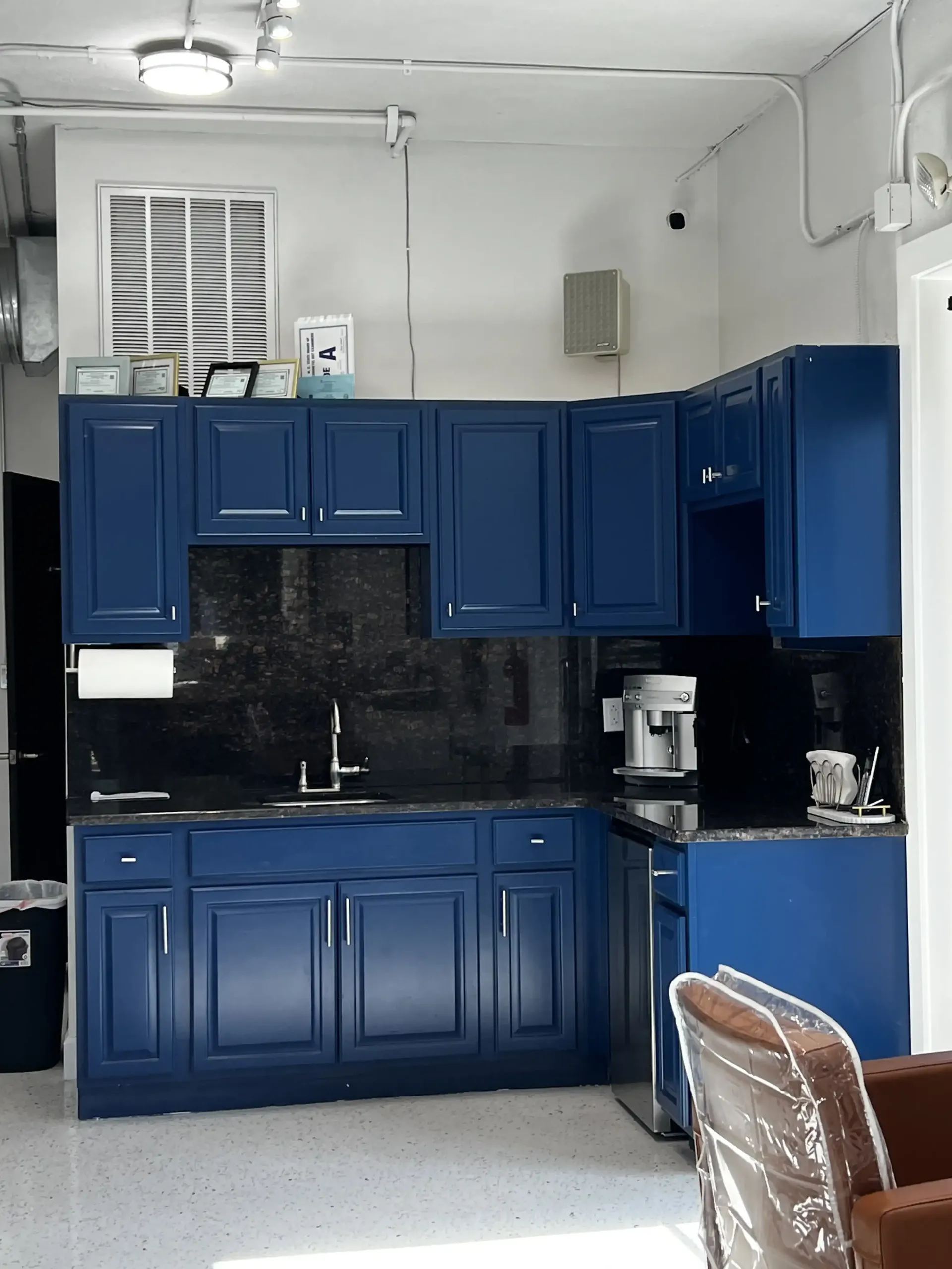 A kitchen with blue cabinets and black counter tops
