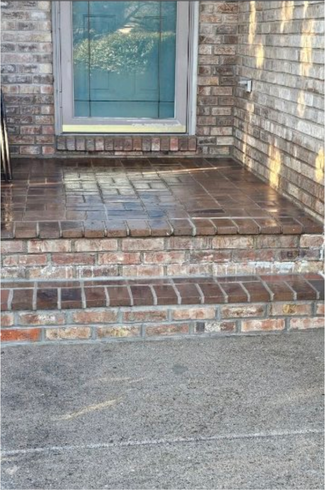 Brick front porch with steps, tiled landing, and a window on the house exterior