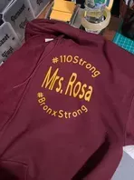 Maroon hoodie with gold text: 
