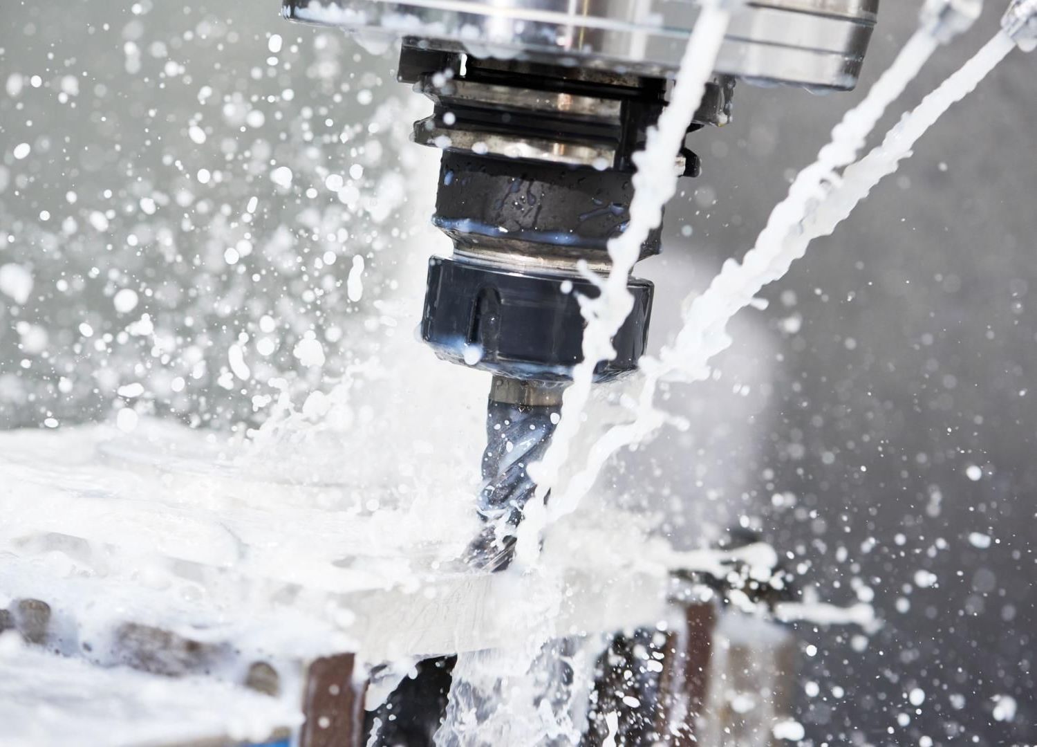 Fraise CNC coupant du métal avec projection de liquide de refroidissement autour