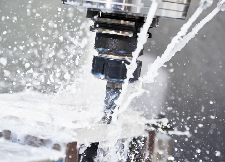 Fraise CNC coupant du métal avec projection de liquide de refroidissement autour
