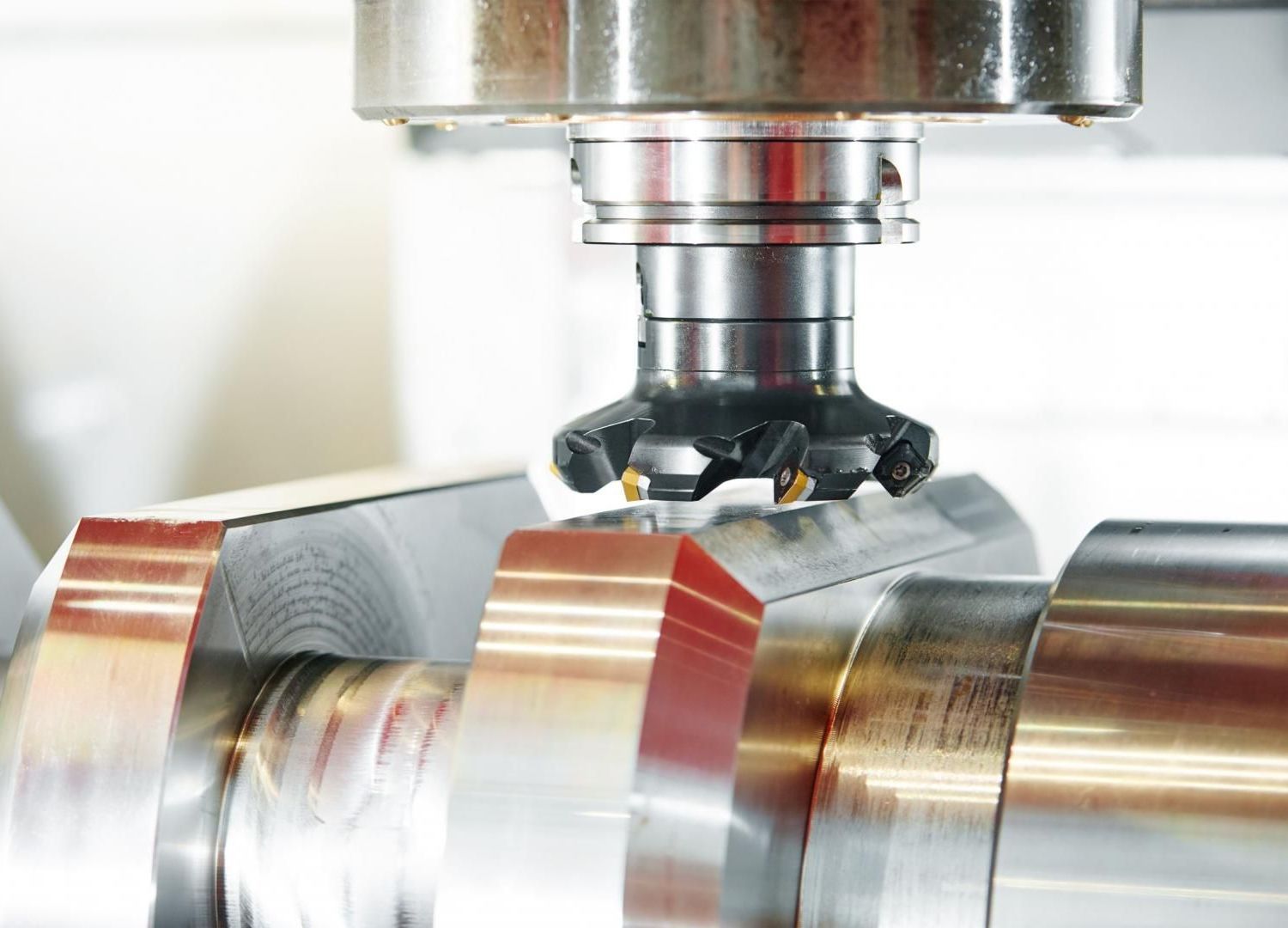 Outil de fraisage CNC coupant un cylindre métallique brillant lors d'un processus d'usinage