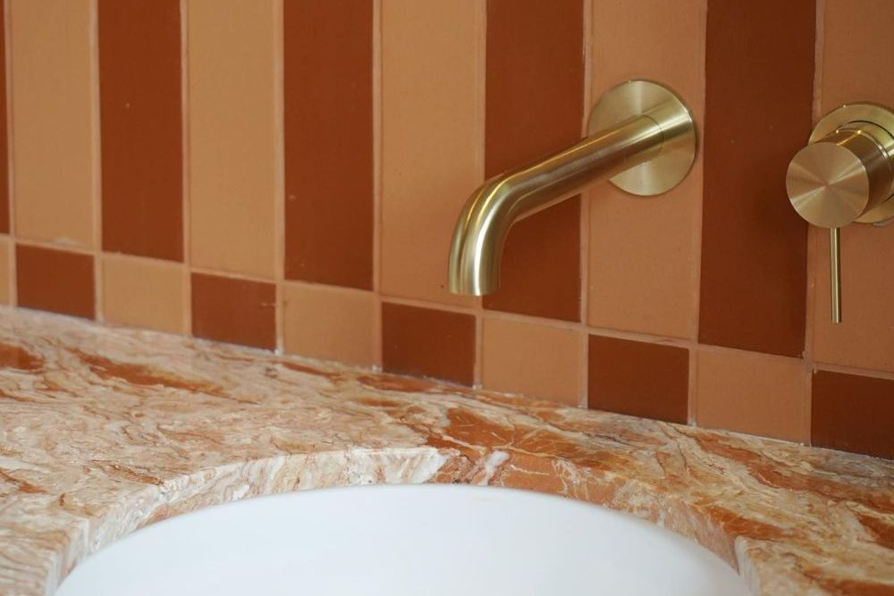 A Bathroom Sink with A Brass Faucet on The Wall — Beith Building & Developments Pty Ltd In Burleigh Heads, QLD
