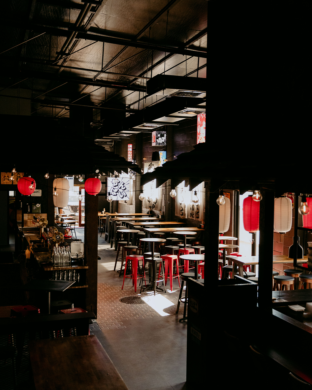 A restaurant filled with tables and chairs and red lanterns. — Beith Building & Developments Pty Ltd In Burleigh Heads, QLD