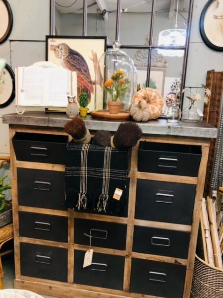 Black cubby dresser with fur accents, plaid fabric, and decor in a rustic home interior
